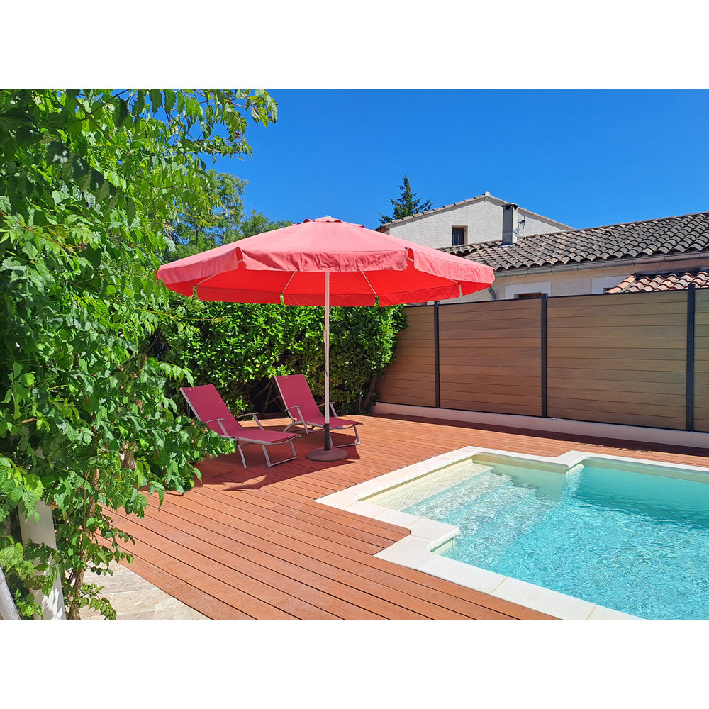 Terrasse en bambou au bord d'une piscine avec parasol